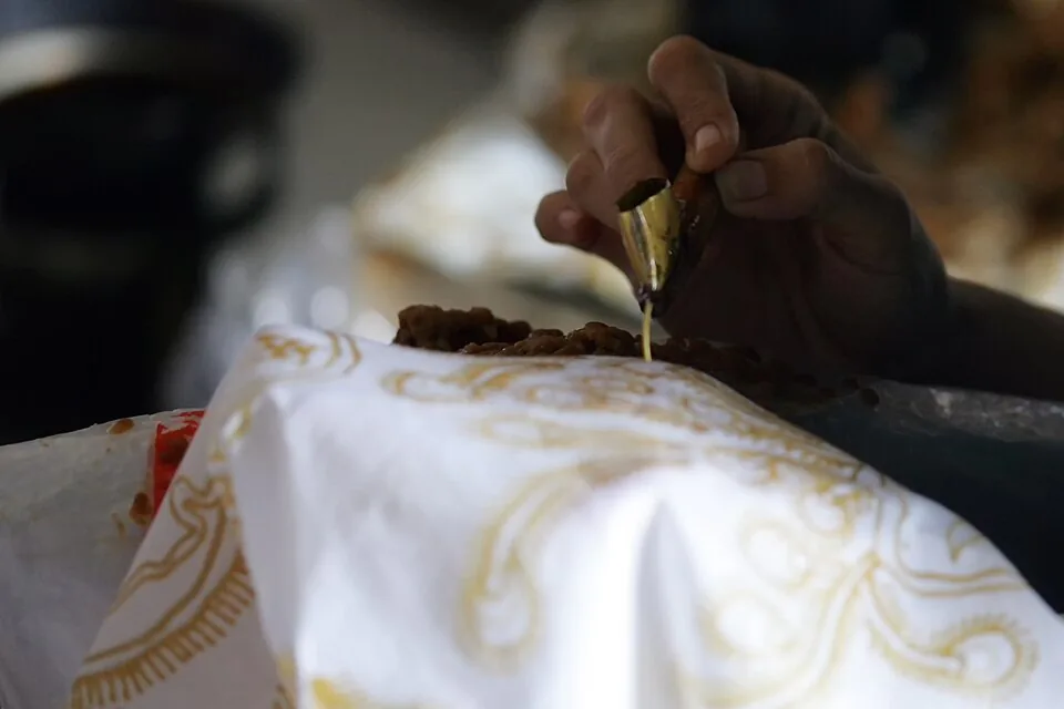Tangan membatik dengan canting di atas kain
