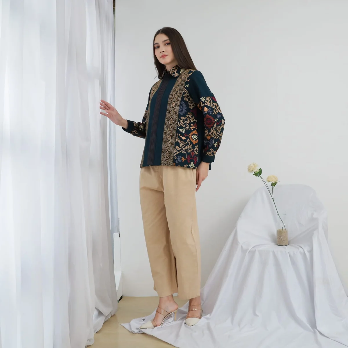 Model mengenakan Kemeja Kirana tenun Bali hijau tua dengan panel motif